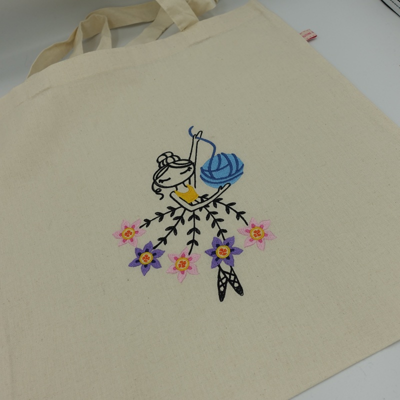 tote bag brodé danseuse robe avec des fleurs et pelote de laine bleue en gros plan